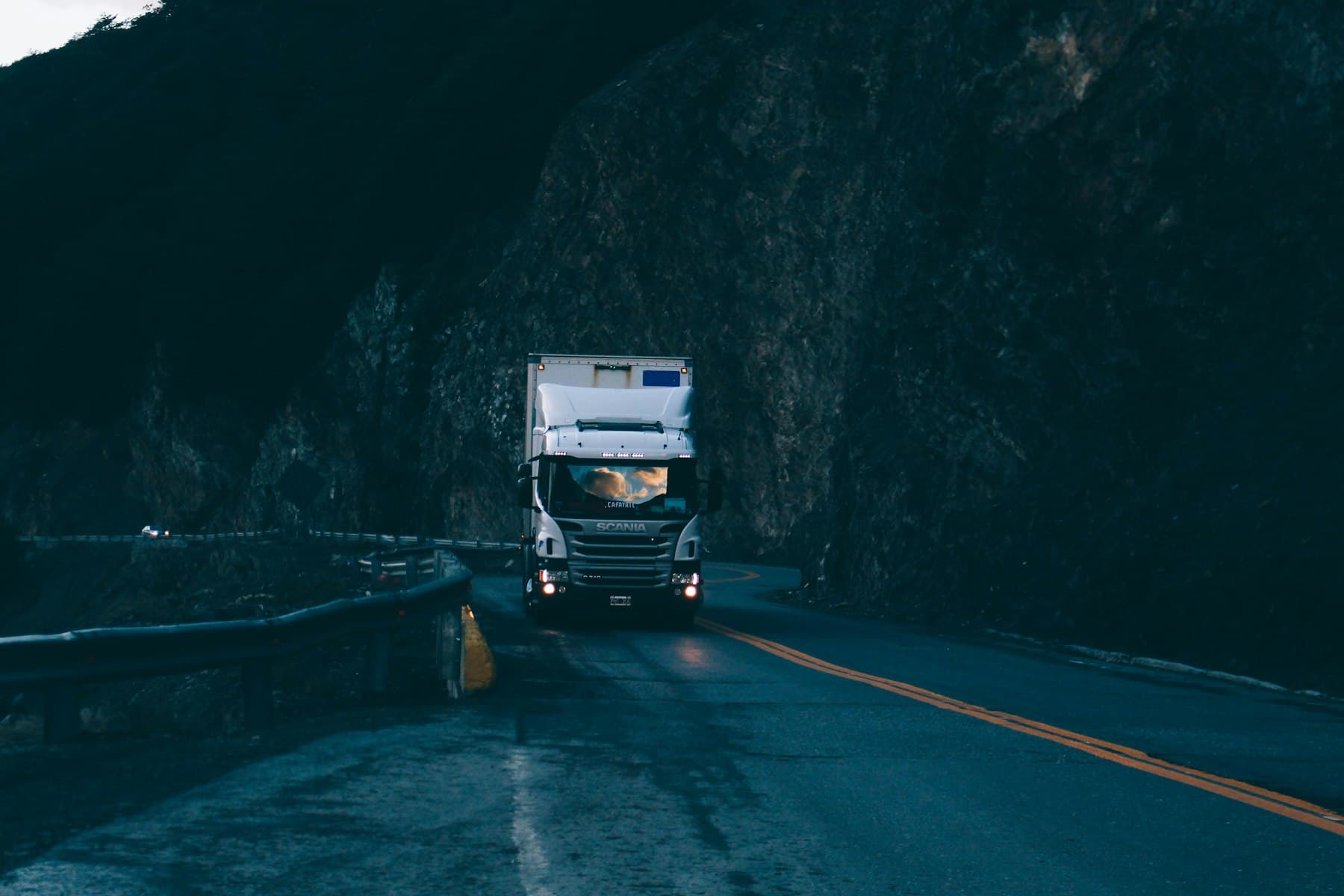Kamion Scania na horské silnici za soumraku